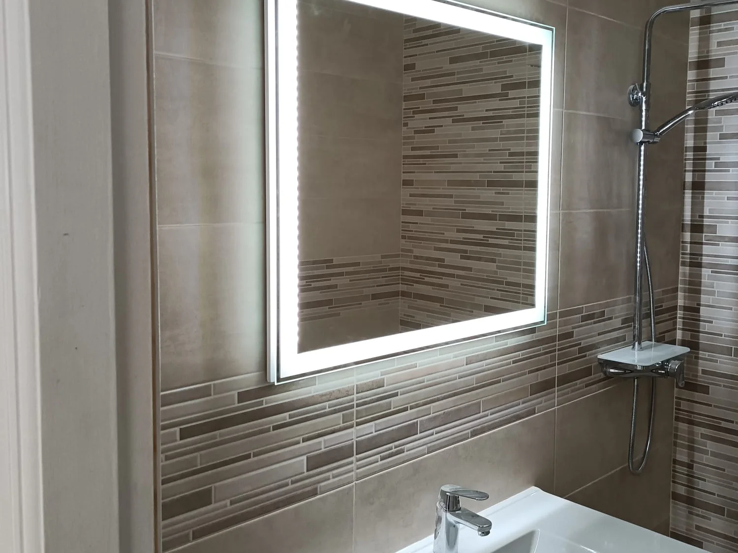 Bathroom renovated by Solteana, finished, with a backlit mirror, tiled border and vanity unit