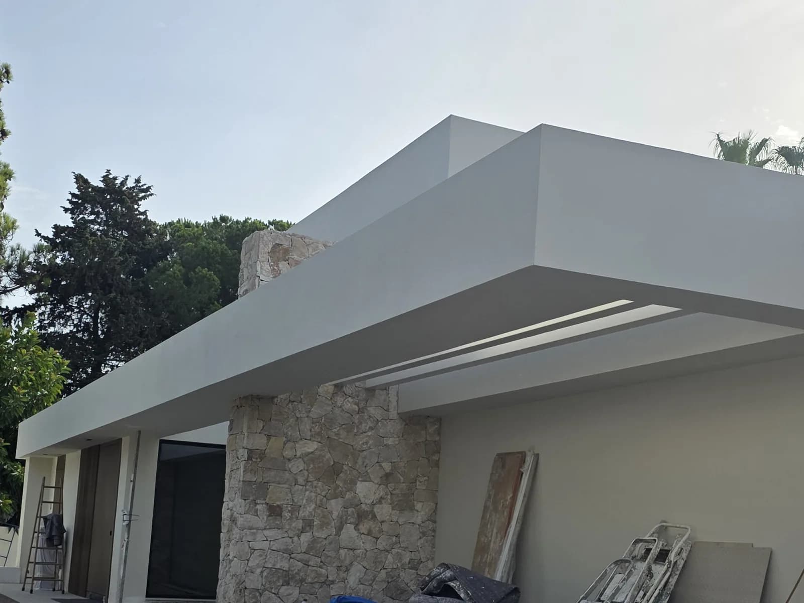 New-build villa constructed by Solteana, with a white cantilevered slab and natural stone cladding