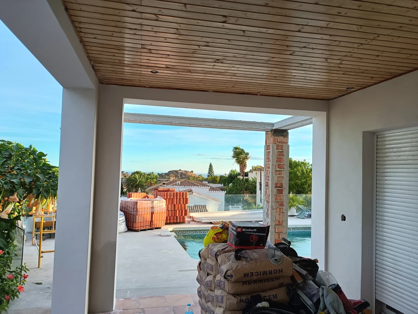 Porch with a timber roof overlooking the pool, on a project in Málaga